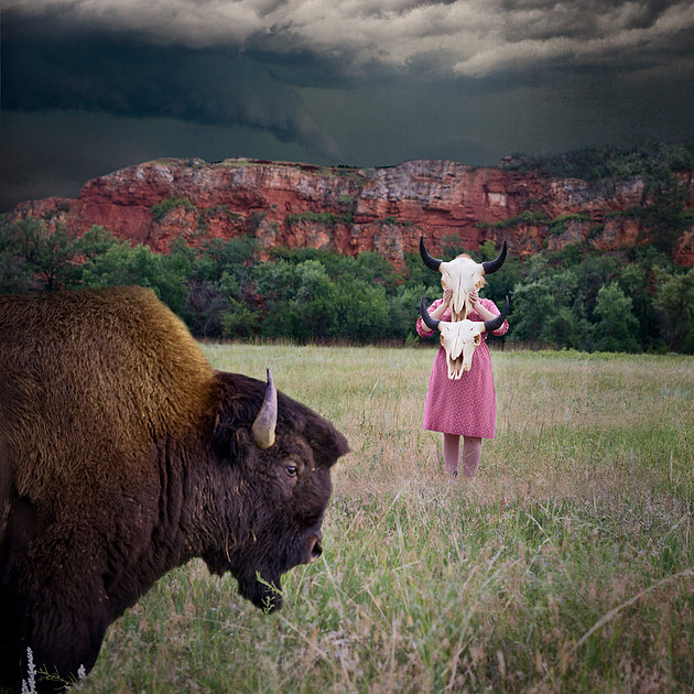 Self portrait photograph with bison skull, buffalo and stormy weather