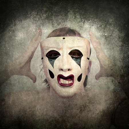 Portrait photograph of woman in sad opera clown mask