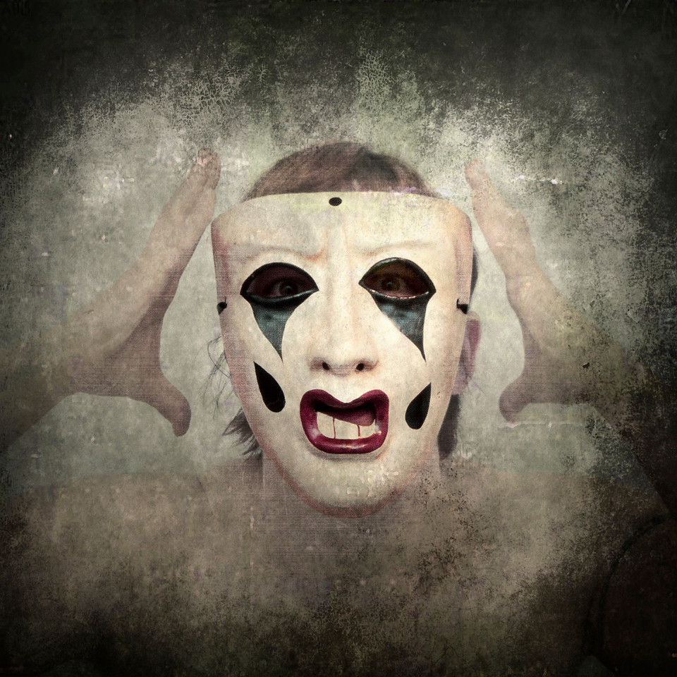 Portrait photograph of woman in sad opera clown mask