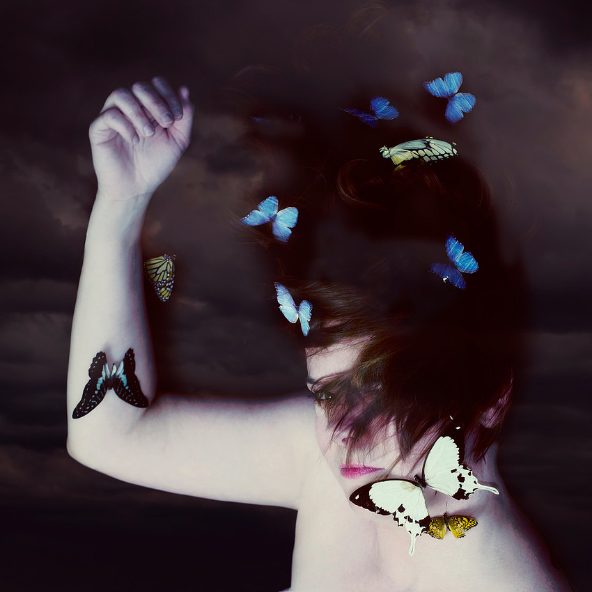 Surreal butterfly portrait, face, woman covered in butterflies