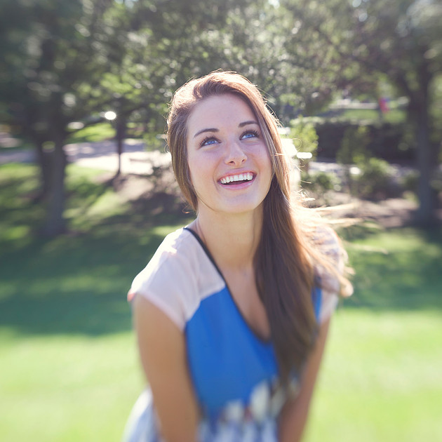 Lensbaby portrait of woman in blue dress outside smiling