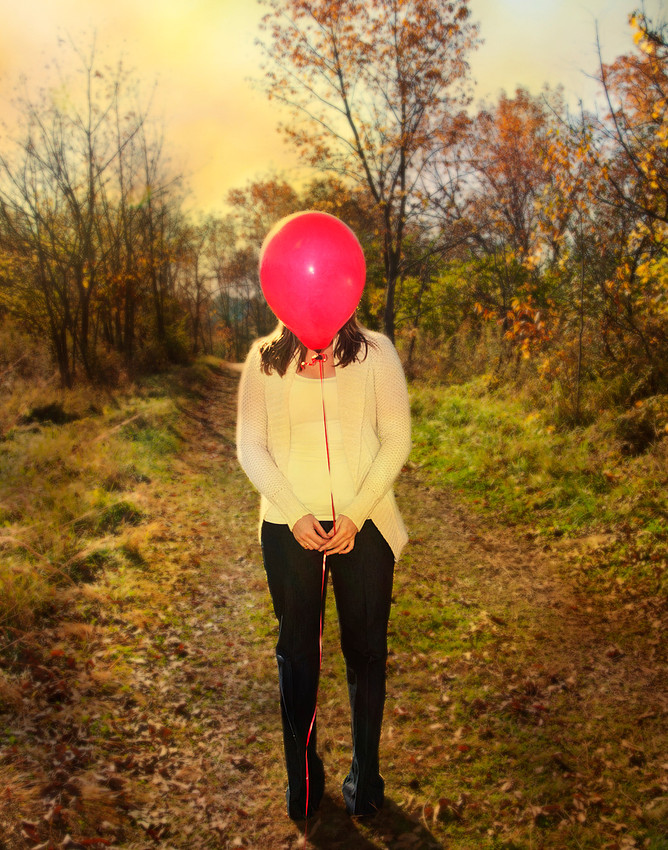 Autumn photo in the forest, woman with red balloon.