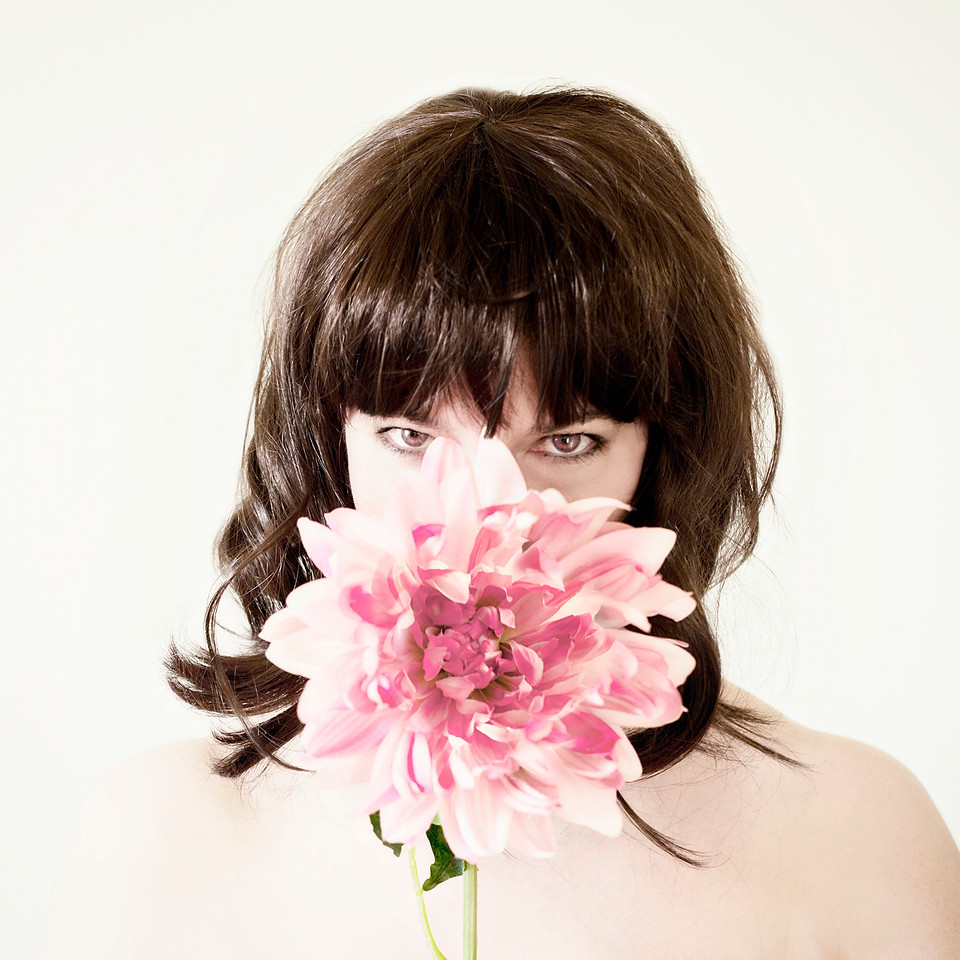 Fine art portrait photography.  Implied nude portrait of a woman with a dahlia.